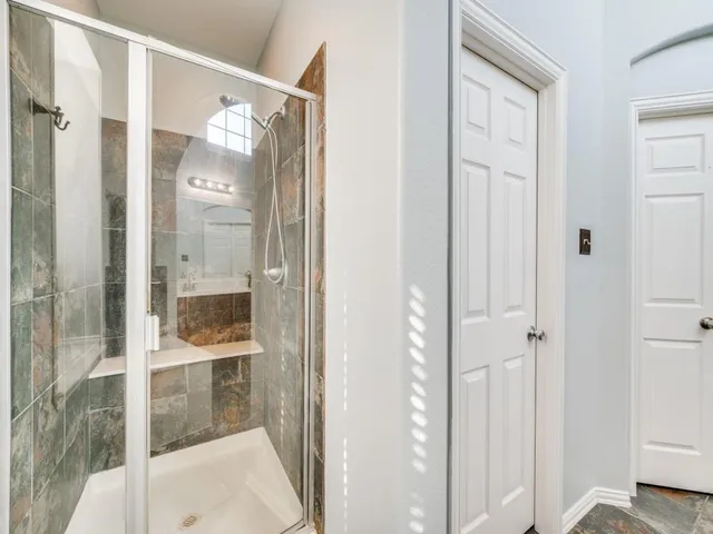 a bathroom with a glass shower door and mirror