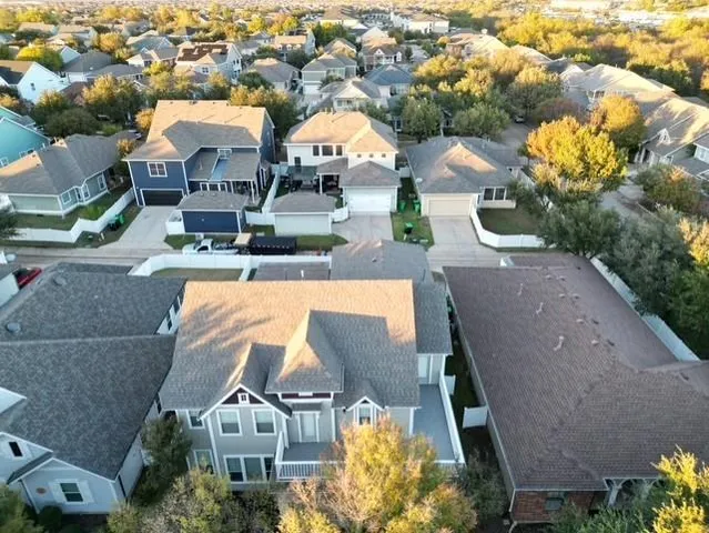 an aerial view of residential houses with outdoor space and swimming pool
