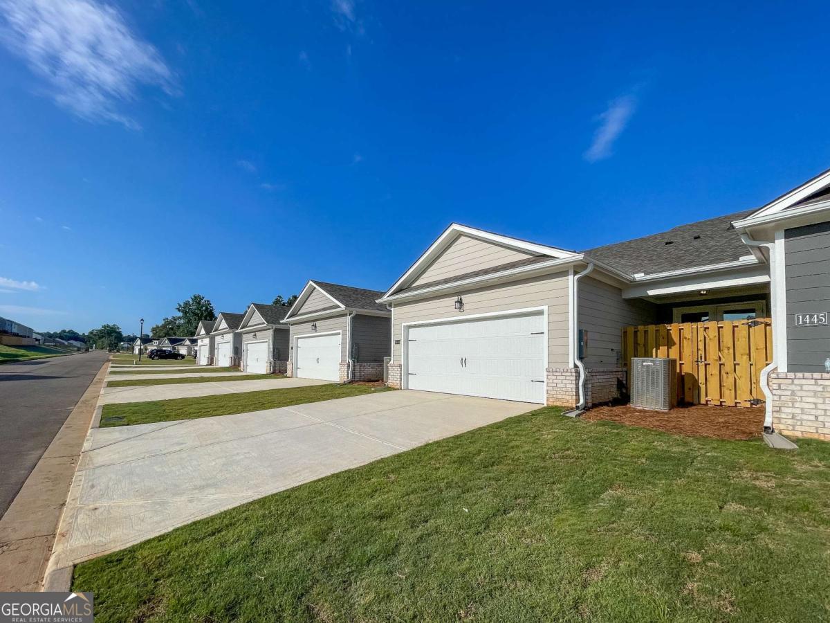 1449 Proust Lane, Unit 1449 Stockbridge, GA 30281 - Photo 3 of 19 a view of a house with a big yard and a large tree