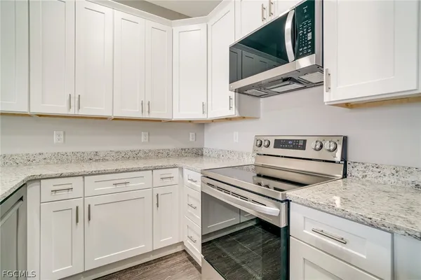 a view of empty room with wooden floor and window