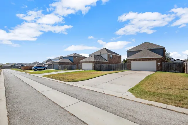 a view of a backyard with wooden fence