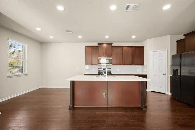 a kitchen with a sink a stove a refrigerator and a microwave
