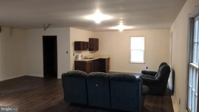 a living room with furniture a flat screen tv and a window