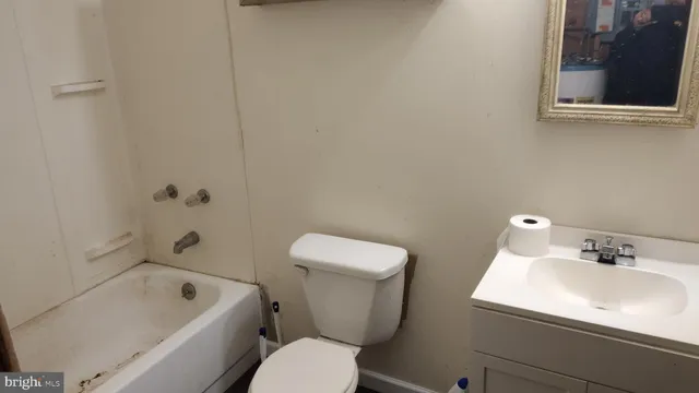 a white toilet sitting next to a bath tub
