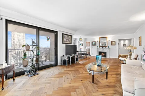 a living room with fireplace furniture and a floor to ceiling window