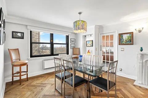 a view of a dining room with furniture a chandelier and wooden floor