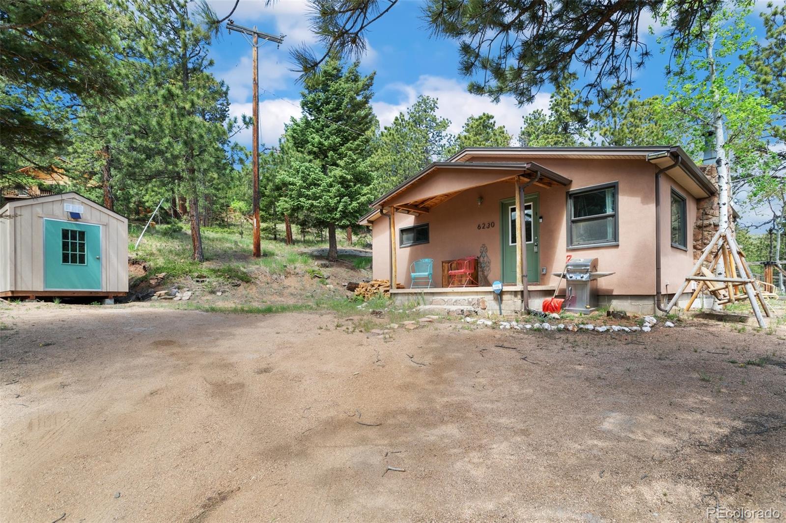 6230 Waterfall Loop Manitou Springs, CO 80829 - Photo 22 of 23 a view of a house with a yard and large trees