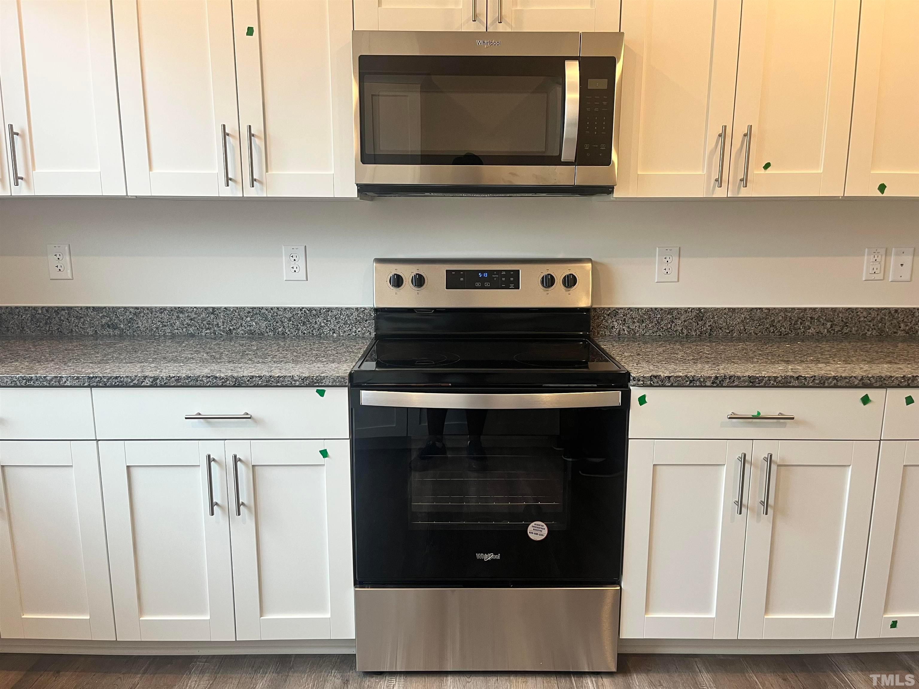 5018 Jayden Drive Durham, NC 27704 - Photo 12 of 22 a kitchen with white cabinets and stainless steel appliances