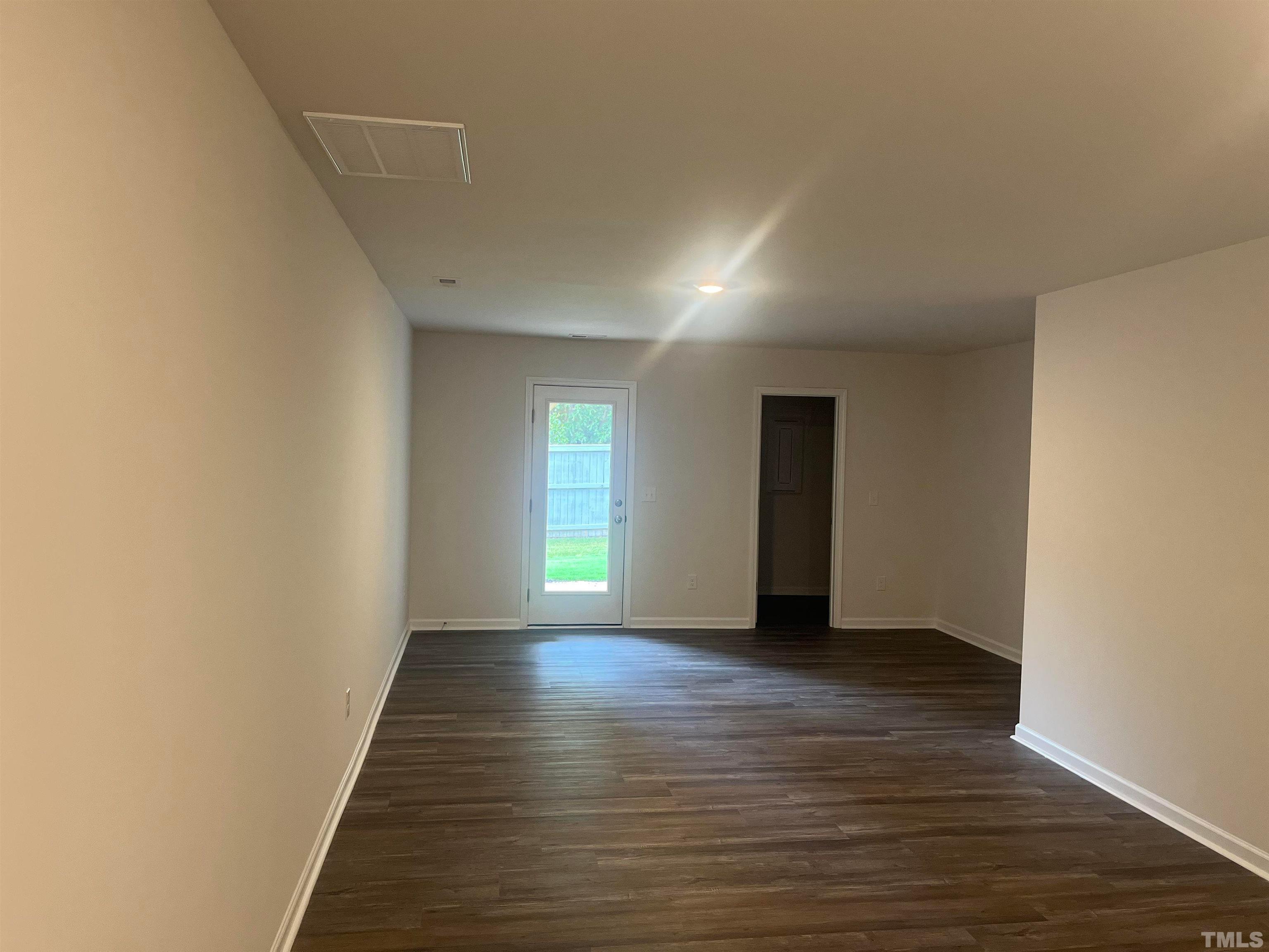 5018 Jayden Drive Durham, NC 27704 - Photo 14 of 22 a view of an empty room with window and wooden floor