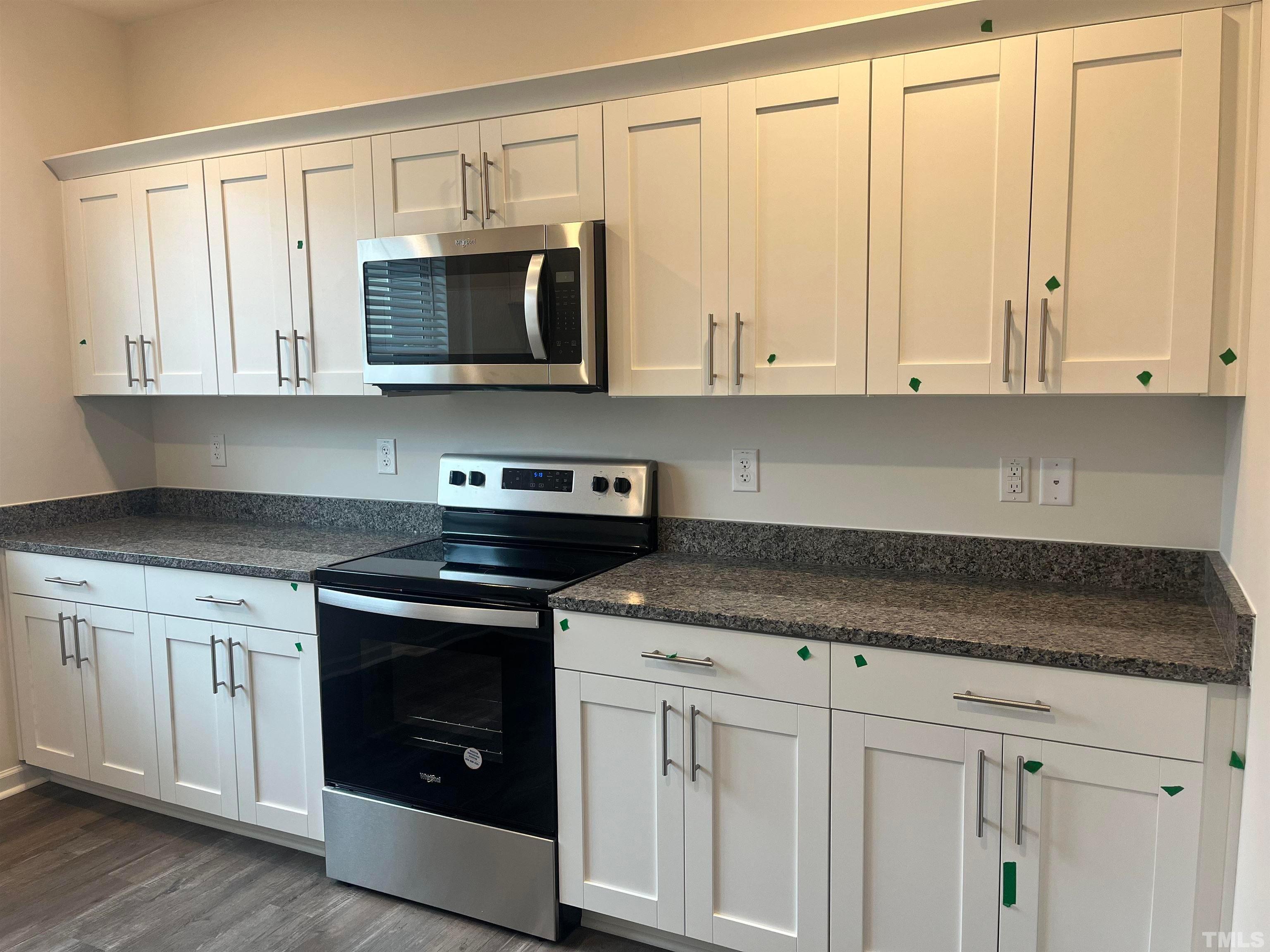 5018 Jayden Drive Durham, NC 27704 - Photo 8 of 22 a kitchen with stainless steel appliances granite countertop white cabinets and a stove top oven