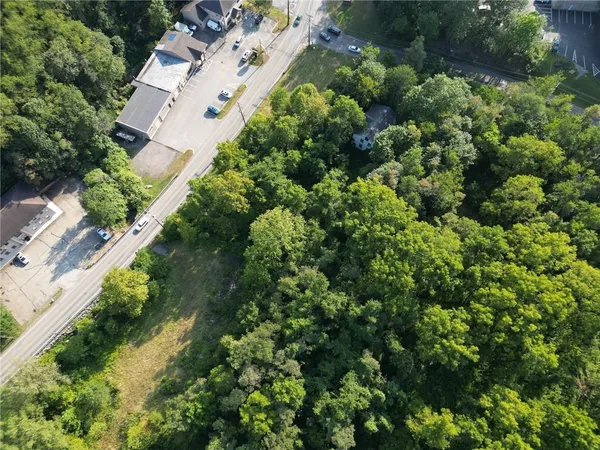 an aerial view of residential house with outdoor space and trees all around