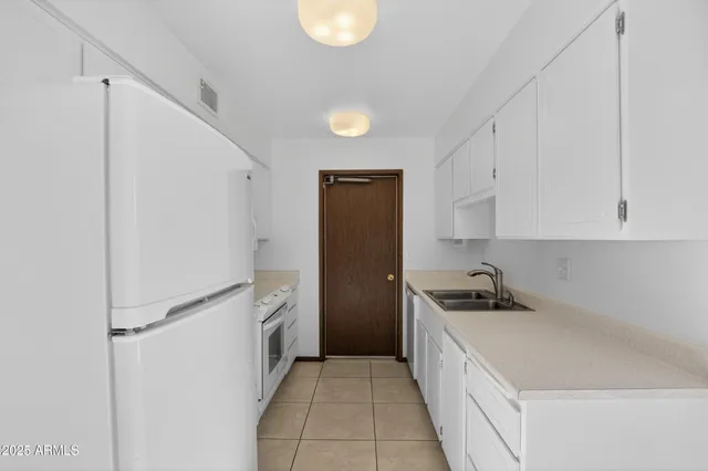 a kitchen with white cabinets and white appliances