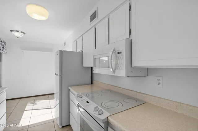 a kitchen with stainless steel appliances granite countertop a sink a stove and a refrigerator