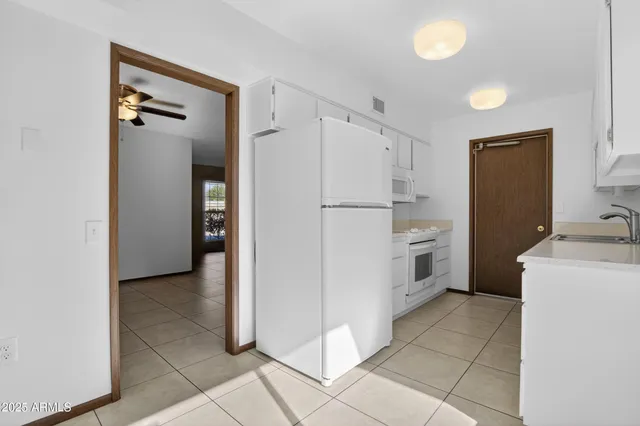 a kitchen with white cabinets and white appliances
