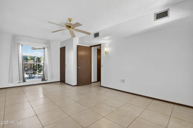 a view of a room with a chandelier fan and windows
