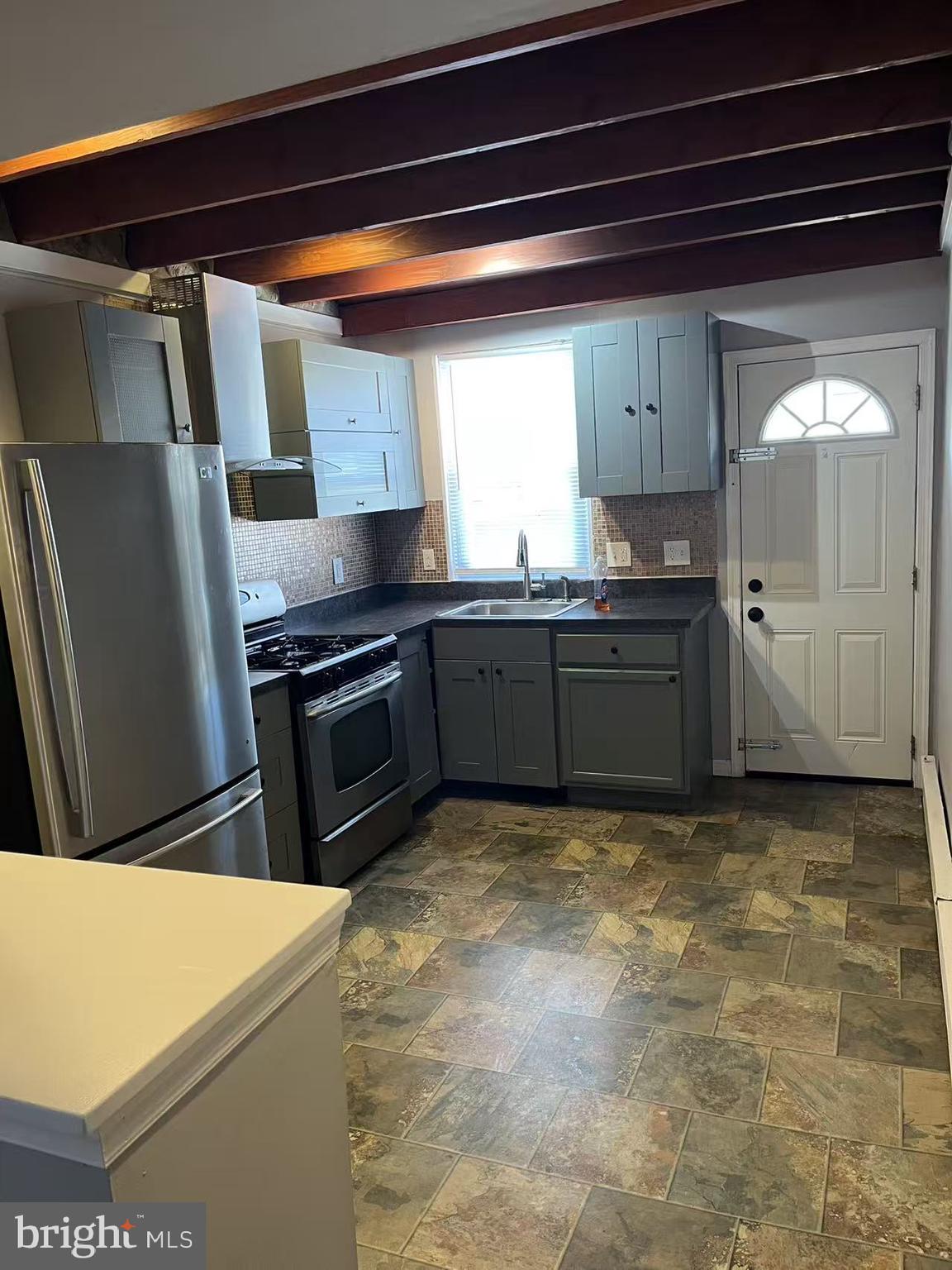 7214 Hegerman Street Philadelphia, PA 19135 - Photo 3 of 6 a kitchen with stainless steel appliances granite countertop a refrigerator and a stove