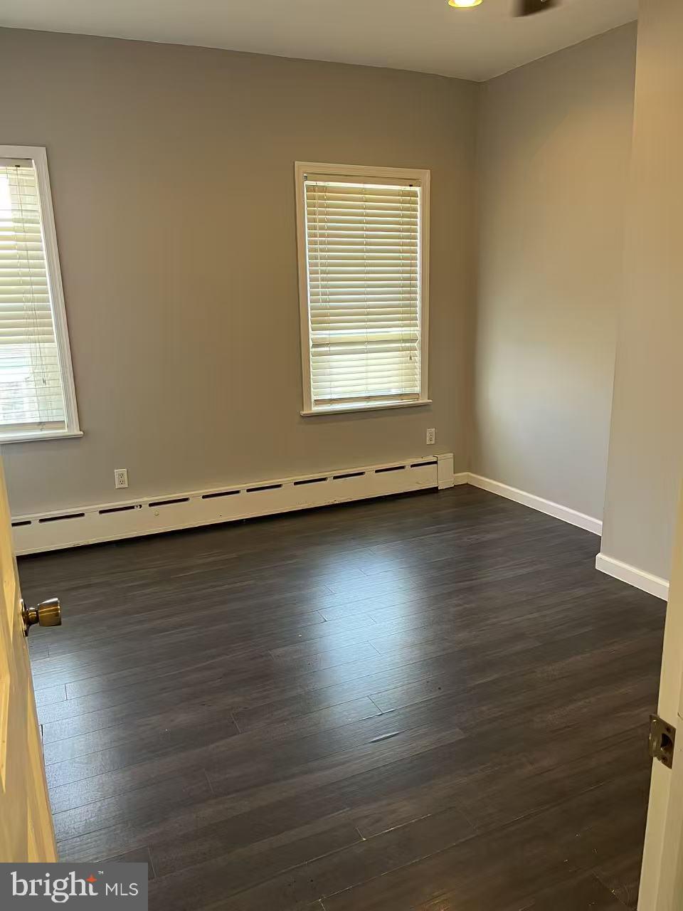 7214 Hegerman Street Philadelphia, PA 19135 - Photo 5 of 6 an empty room with wooden floor and windows