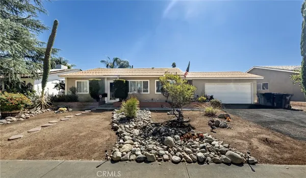 a front view of house with a garden