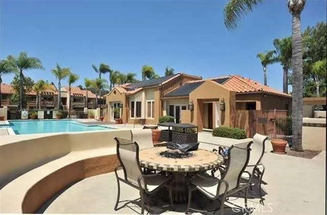 a view of a patio with table and chairs potted plants and palm tree