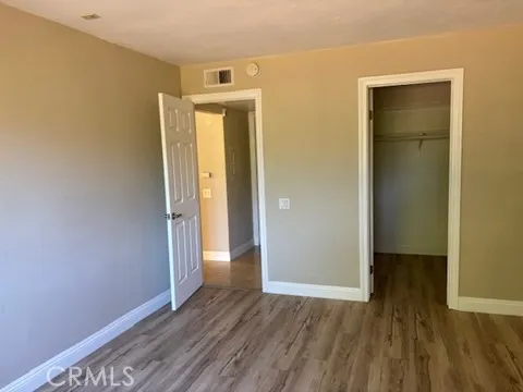 an empty room with wooden floor and closet