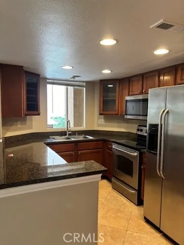 a kitchen with granite countertop a sink and stainless steel appliances