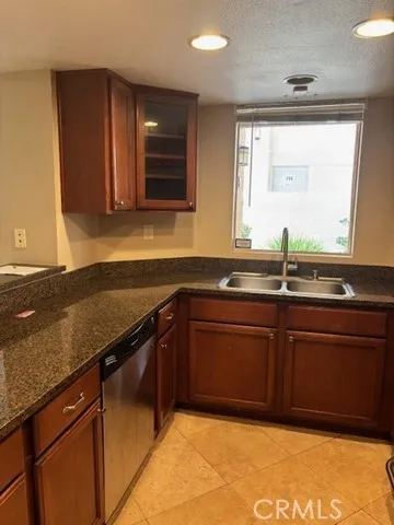 a kitchen with granite countertop a sink and a wooden cabinets