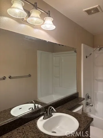 a bathroom with a sink a toilet and mirror