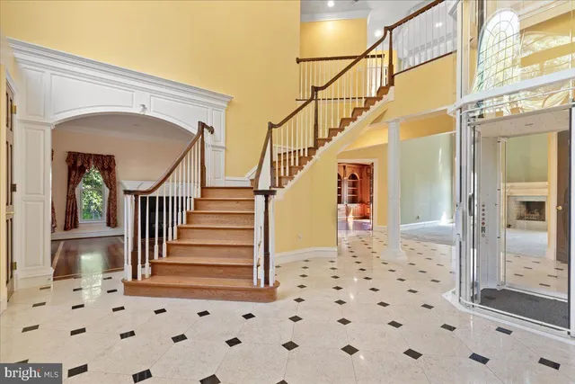 a view of an empty room with wooden floor fireplace and a window