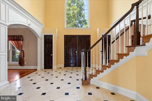 a view of an empty room with wooden floor fireplace and a window