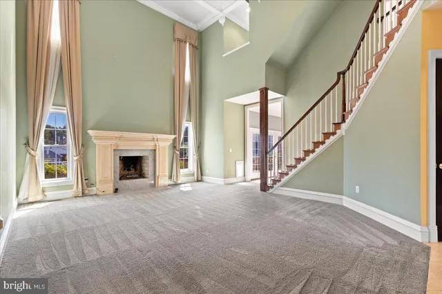 a hallway with wooden floor windows and a chandelier