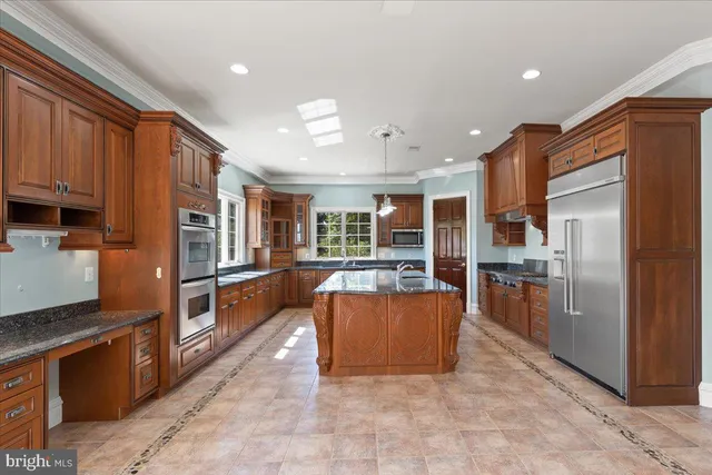 a kitchen with stainless steel appliances granite countertop a refrigerator and a stove
