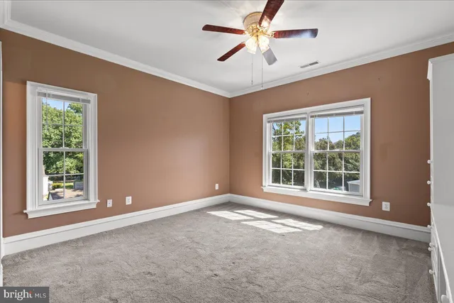 an empty room with a window and a ceiling fan