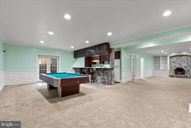 a large living room with stainless steel appliances a large window a table and chairs