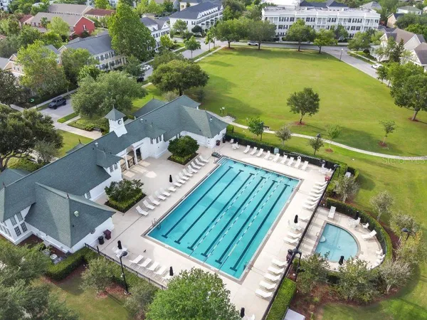 a view of a white house with a large space and a yard