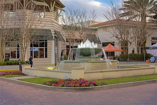 a view of a lake with a table and chairs and potted plants