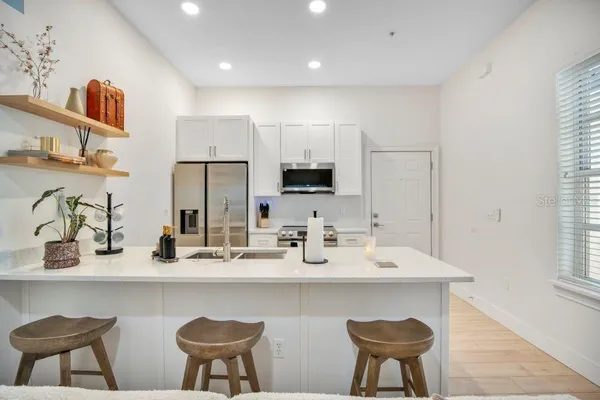 a kitchen with stainless steel appliances a sink and a refrigerator