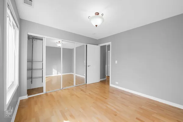 a view of a livingroom with wooden floor and a ceiling fan