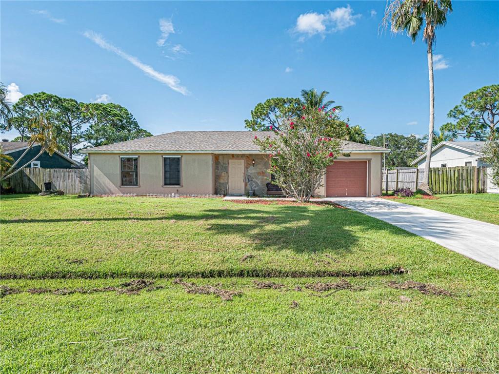 662 Southeast Ron Rico Terrace Port St. Lucie, FL 34983 - Photo 1 of 27 a front view of a house with garden