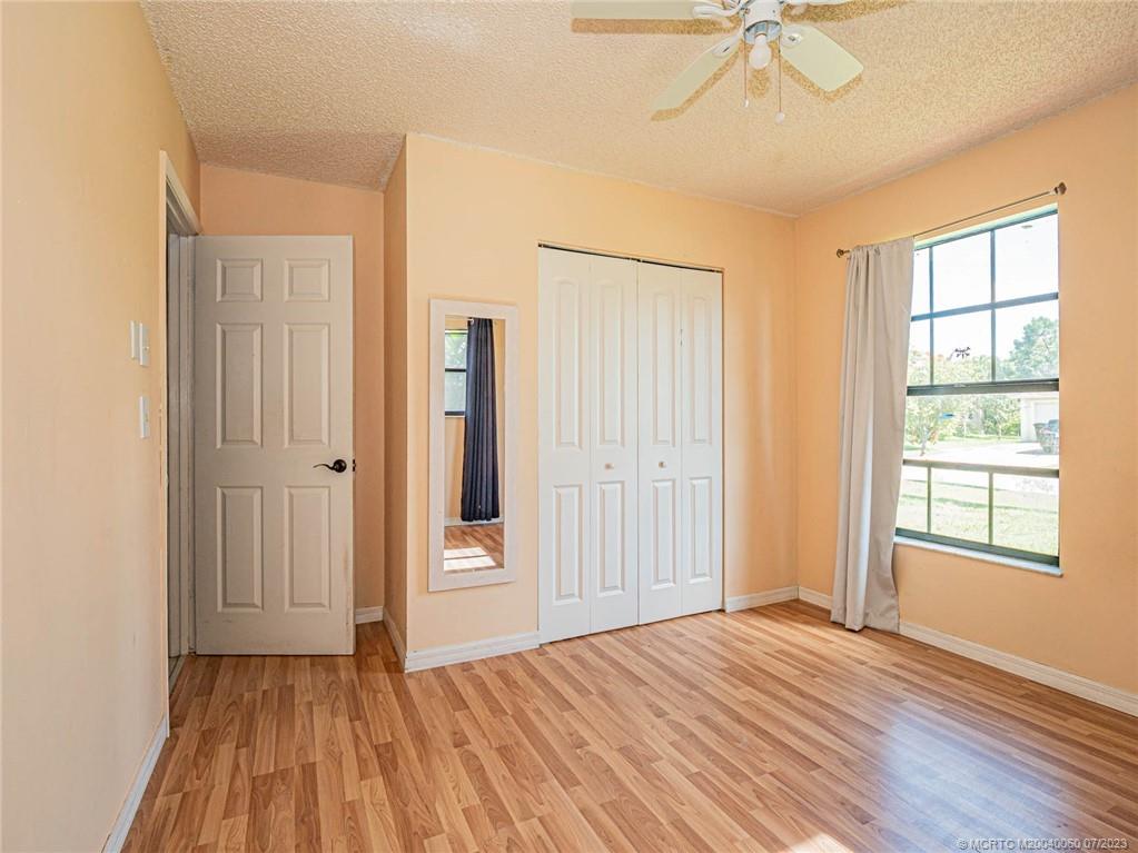 662 Southeast Ron Rico Terrace Port St. Lucie, FL 34983 - Photo 13 of 27 an empty room with wooden floor fan and windows