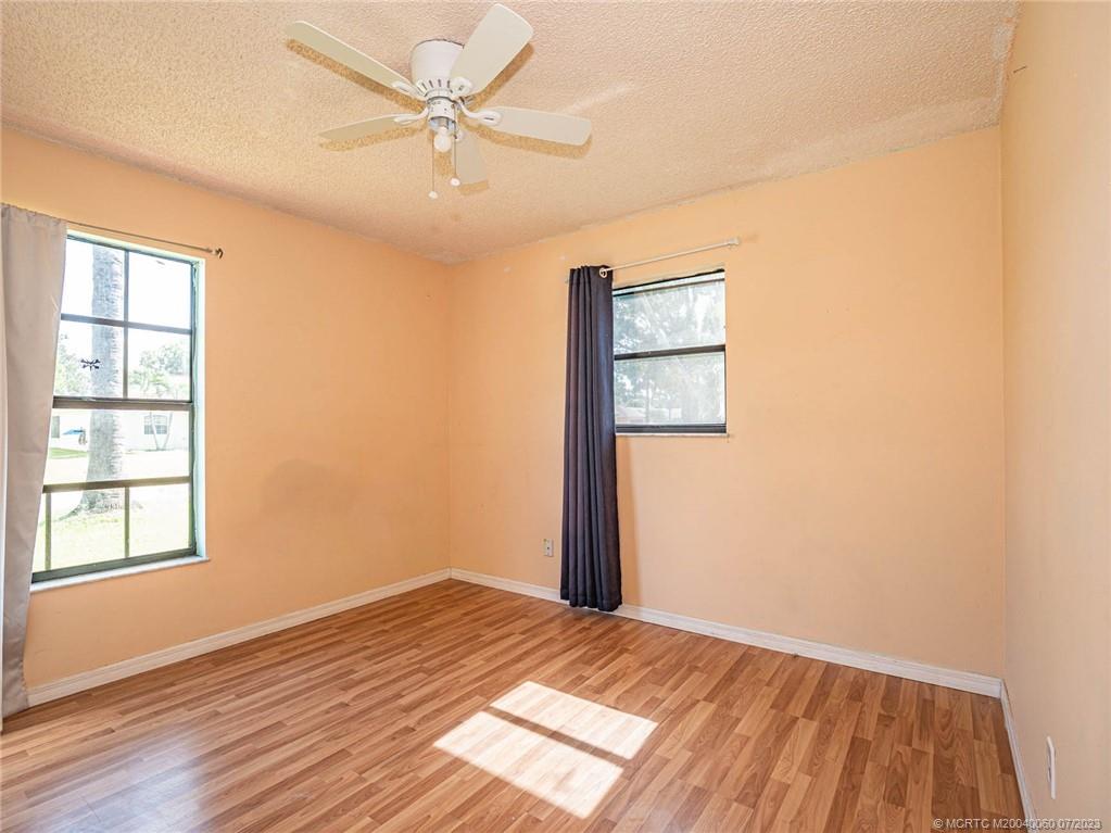 662 Southeast Ron Rico Terrace Port St. Lucie, FL 34983 - Photo 14 of 27 an empty room with wooden floor closet and windows