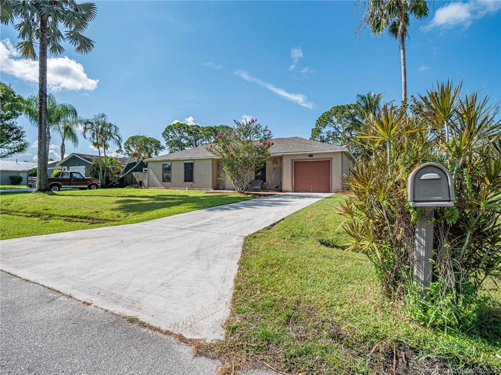 662 Southeast Ron Rico Terrace Port St. Lucie, FL 34983 - Photo 25 of 27 a front view of a house with a garden and yard