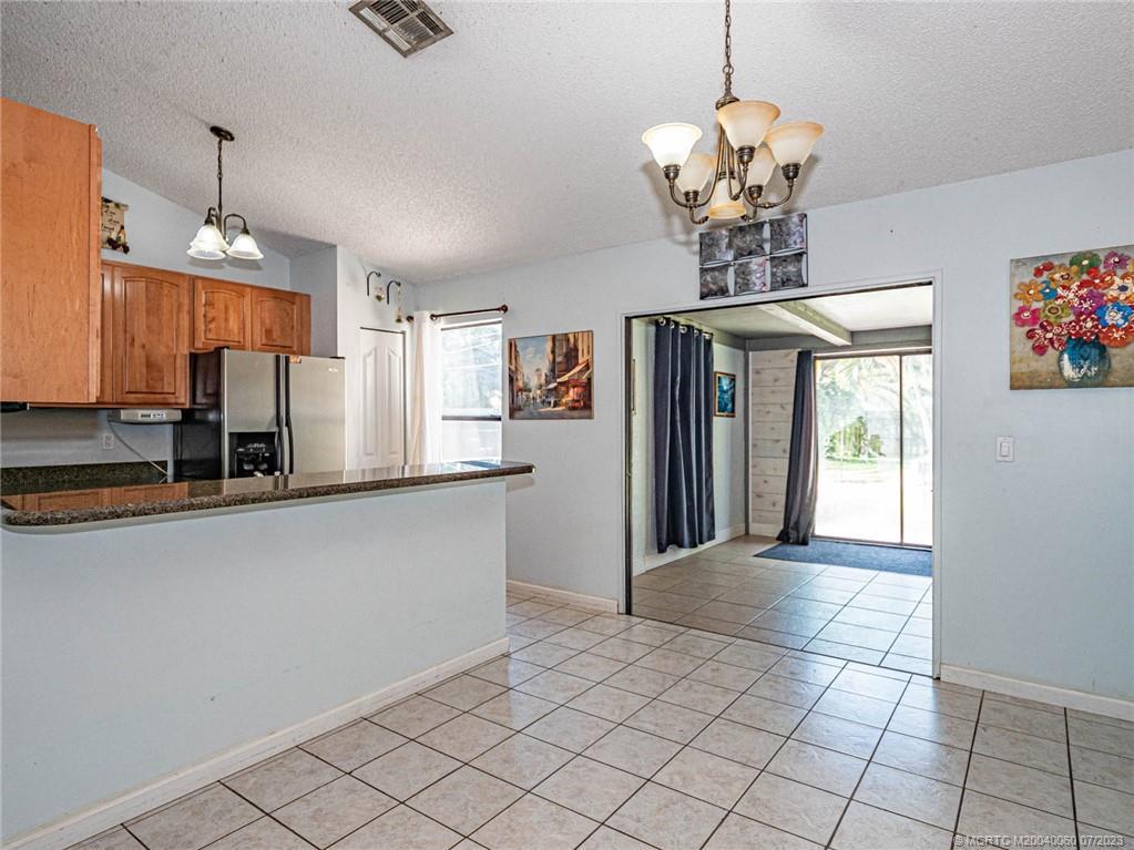 662 Southeast Ron Rico Terrace Port St. Lucie, FL 34983 - Photo 4 of 27 a view of a kitchen with a sink and chandelier