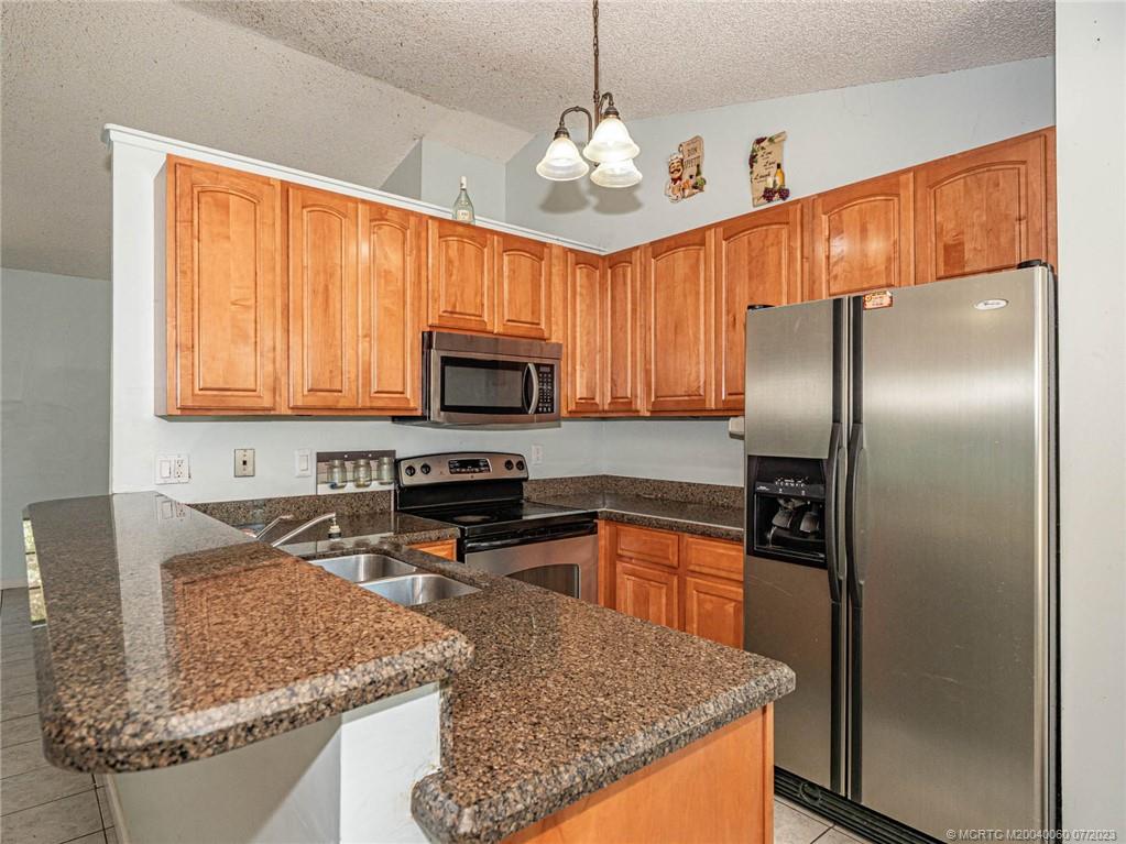 662 Southeast Ron Rico Terrace Port St. Lucie, FL 34983 - Photo 6 of 27 a kitchen with stainless steel appliances granite countertop a sink stove and refrigerator