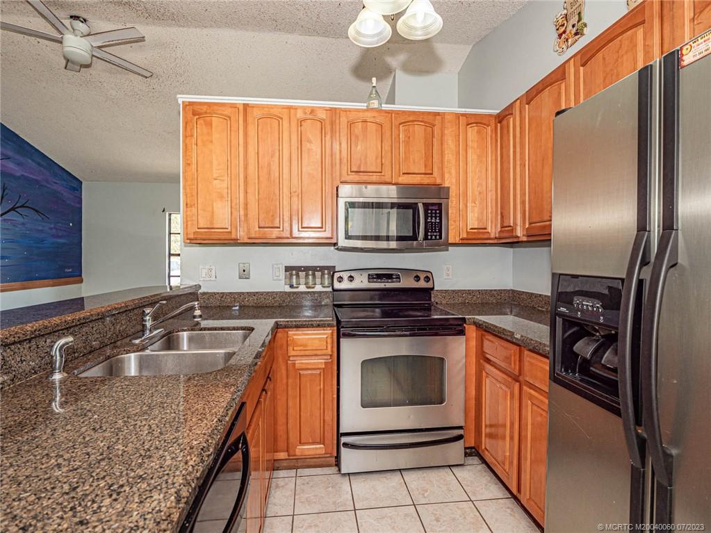 662 Southeast Ron Rico Terrace Port St. Lucie, FL 34983 - Photo 7 of 27 a kitchen with stainless steel appliances granite countertop a stove sink microwave and refrigerator