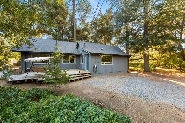 a view of a house with a garden and trees