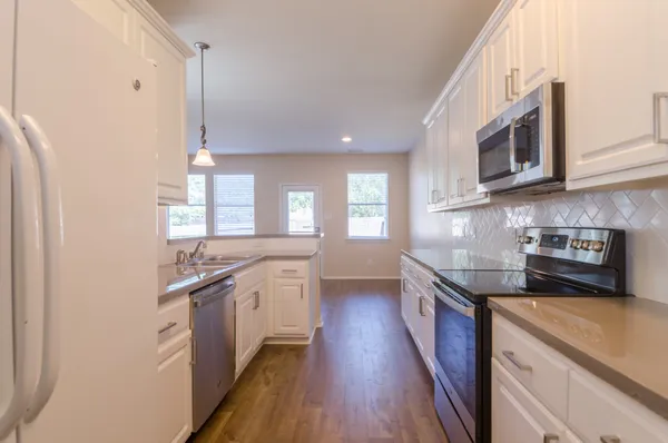 a kitchen with stainless steel appliances granite countertop a sink stove and refrigerator