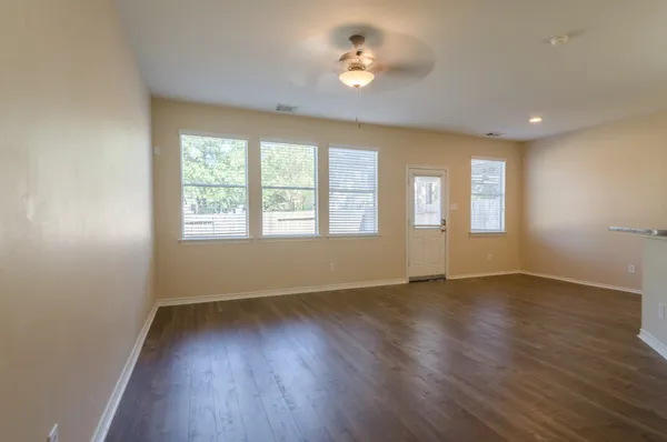 an empty room with wooden floor and windows