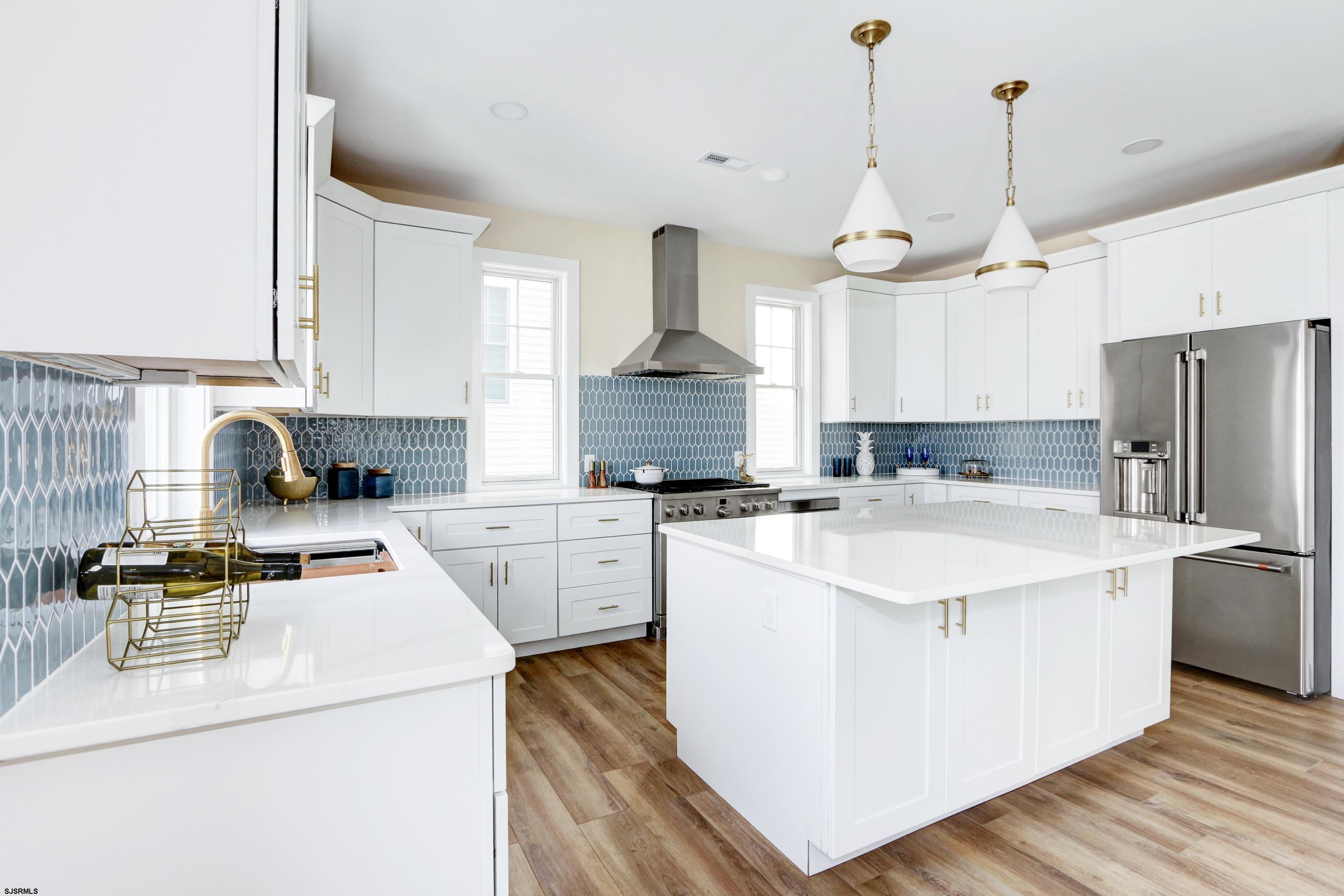 303 Lafayette Place Brigantine, NJ 08203 - Photo 13 of 38 a kitchen with a sink a stove a refrigerator and white cabinets