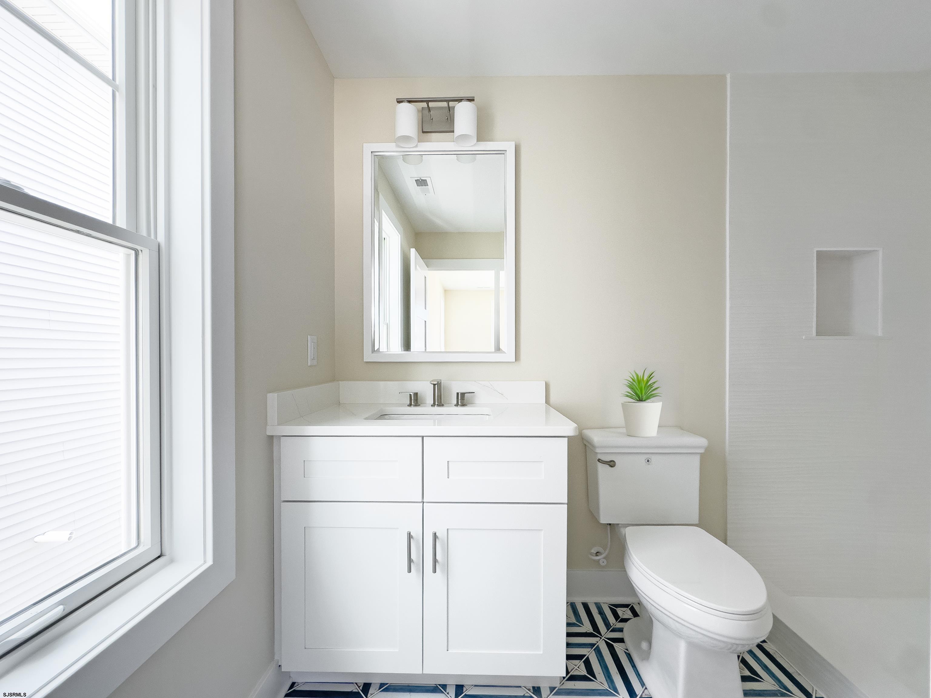 303 Lafayette Place Brigantine, NJ 08203 - Photo 15 of 38 a bathroom with a toilet sink and mirror
