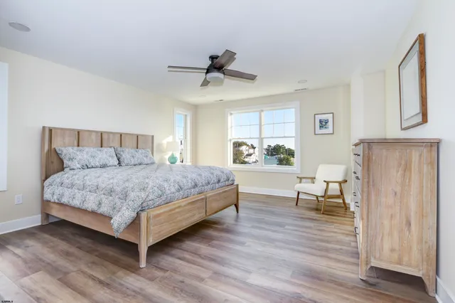 a bedroom with a bed and a dresser next to a window